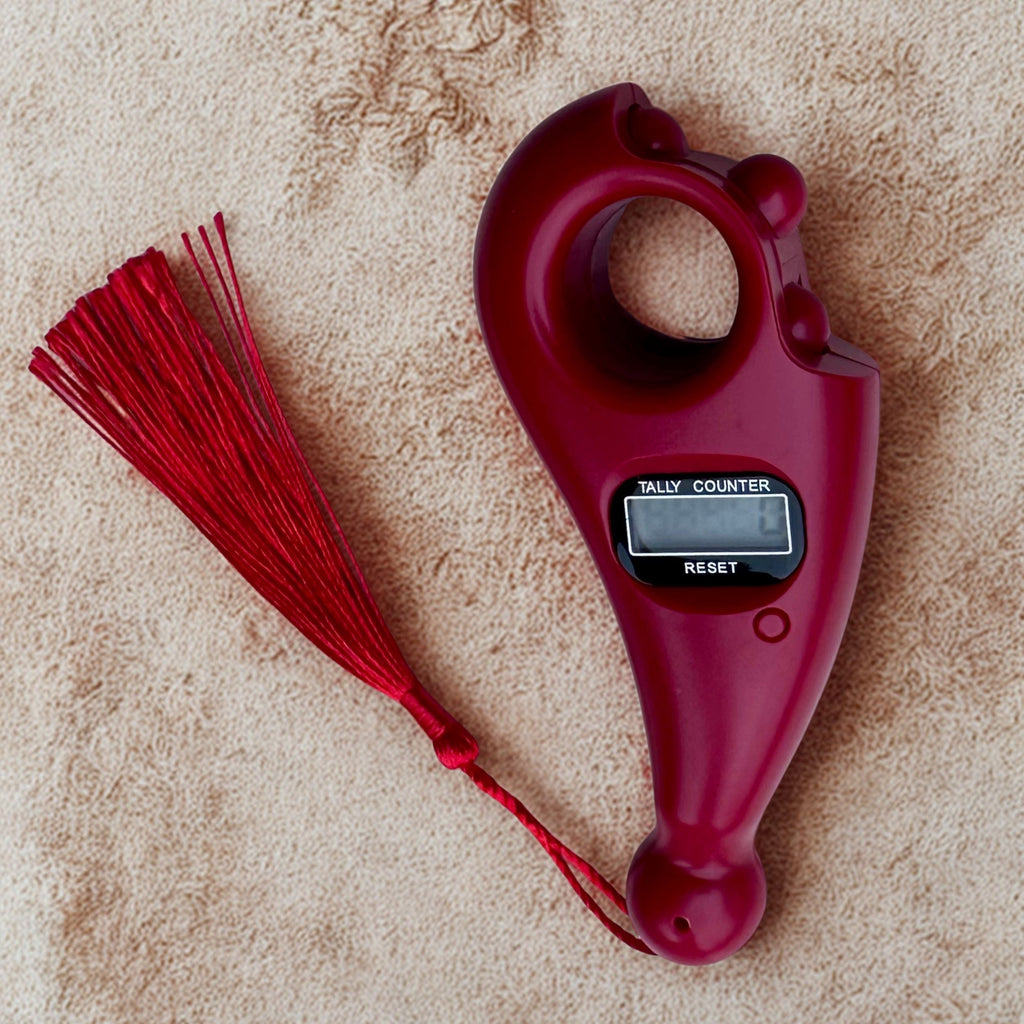 Red clicker with digital counter on a beige surface